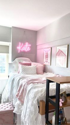 a bed room with a neatly made bed and a pink neon sign above the bed