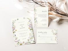 the wedding stationery is laid out next to some dried flowers