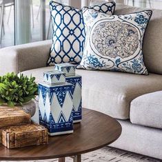 two blue and white vases sitting on top of a table next to a couch