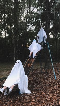 two ghost like figures on a slide in the woods