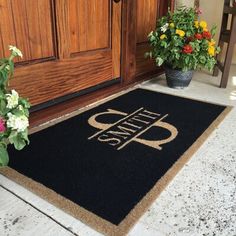 a door mat with the words open on it next to flowers and potted plants