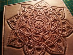 a brown leather book with an intricate design on it