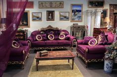 a living room filled with purple couches and furniture