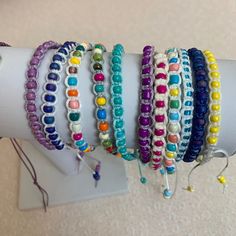 a bunch of bracelets that are on top of a white armband with beads