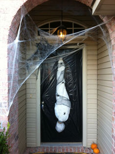 a white stuffed animal hanging from the side of a door in front of a house