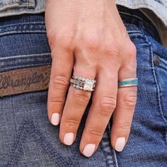 a woman's hand with two rings on her finger and one ring in the other