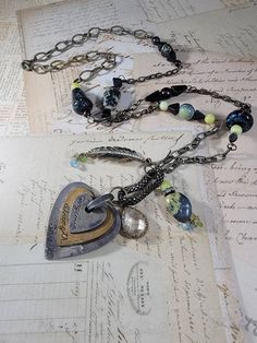 "Art Assemblage Necklace: I created the long necklace by building it around a Mixed Metal heart that says \"gorgeous strength, and spirit\" with some odd charms from salvaged jewelry.  There are stone and Czech glass beads, and brass feather charms, chips, chrystal charm and patinaed brass chains. The eclectic mix is very organic, natural and endearing. It measures 33 inches long with a 4 inch pendant that is adjustable with a lobster clasp." Spiritual Heart Pendant Necklaces For Jewelry Making, Spiritual Heart Pendant Necklace For Jewelry Making, Unique Metal Jewelry With Heart Charm, Metal Heart Beads For Jewelry Making, Artisan Heart Beads Pendant Necklace, Bohemian Metal Jewelry With Heart Charm, Bohemian Heart-shaped Metal Necklaces, Bohemian Heart-shaped Metal Charm Necklace, Bohemian Silver Necklace With Heart Charm