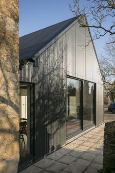 the house is made out of metal and has sliding glass doors to let in natural light