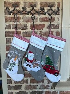 two christmas stockings hanging on a brick wall