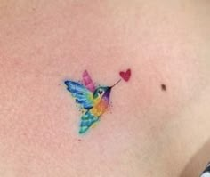 a colorful hummingbird with a heart tattoo on its chest