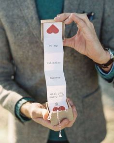 a man in a suit holding up a piece of paper with words written on it