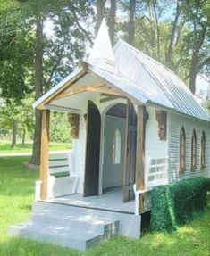 a small white house sitting on top of a lush green field