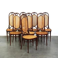 six chairs with wicker seats are lined up