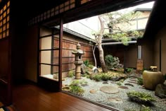 an open door leading to a small garden with rocks and trees in the middle of it