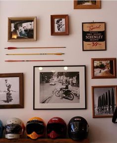 a wall with many framed pictures and helmets on it