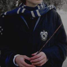 a young man holding a harry potter wand in his hands