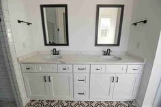 a bathroom with two sinks, mirrors and tiled flooring in the shower stall area