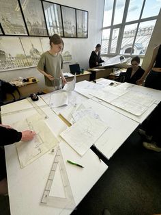 several people sitting around a table with papers and pencils on it in an office