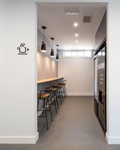 an empty room with several stools and a vending machine on the wall next to it