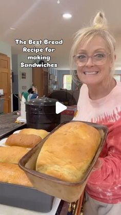 a woman holding a loaf of bread on top of a pan