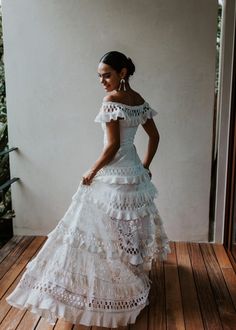 a woman in a white dress standing on a wooden floor