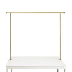 a white table with gold legs and a shelf on the top that has a single sheet of paper underneath it