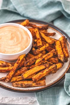 french fries on a plate with dipping sauce