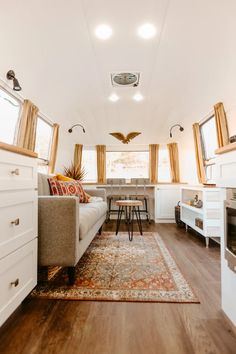 a living room filled with furniture next to a kitchen and dining area on top of a hard wood floor