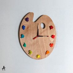 a wooden clock with colorful candies painted on it's face and the hands