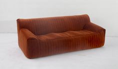 a brown couch sitting on top of a white floor