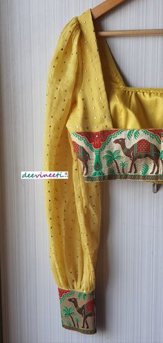 This Made to Order/Made to Measurement/Custom Made Indian Ethnic Blouse. - Fabric - Mul Cotton with Gold Mukaish Dots - Color - Yellow - Padded - Princess Cut - U Neck - Puffed Full Length Sleeves with Multicolor Border - Back Hook Closure - Border at the back Fabric Care : Dry Clean Only Disclaimer: The actual color of the product might slightly differ from the image due to photographic lighting or monitor's display Shipping: This is made to order product. Once you place the order we will provi Bohemian Fitted Lehenga For Puja, Bohemian Semi-stitched Self Design Choli, Bohemian Festive Blouse With Zari Work, Festive Bohemian Blouse With Zari Work, Bohemian Blouse With Self Design For Eid, Yellow Festive Blouse For Eid, Festive Traditional Drape Blouse For Festival, Bohemian Blouse With Zari Work For Eid, Bohemian Chanderi Blouse With Pallu