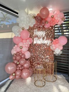 there is a large balloon arch with pink and white balloons on it in the room