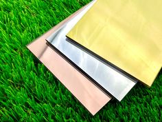 two sheets of paper sitting on top of green grass