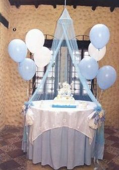 a baby shower table with blue and white balloons