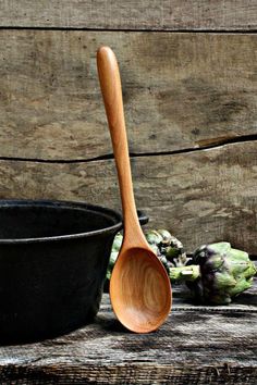 a wooden spoon sitting next to a black bowl