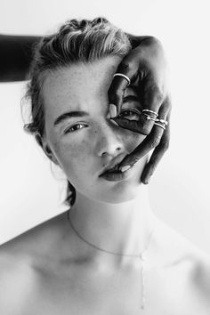 a black and white photo of a woman holding her hands up to her face with the other hand