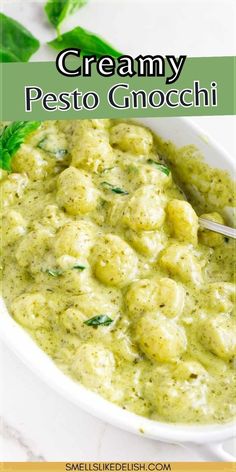 creamy pesto gnocchi in a white bowl with basil garnish on top