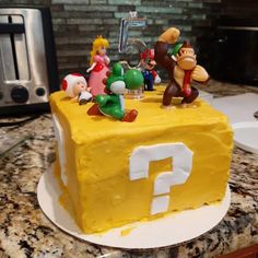 a yellow cake with mario and other characters on it