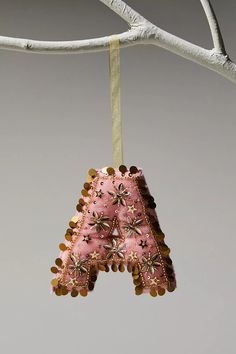 an ornament hanging from a tree branch with beads and bead work on it