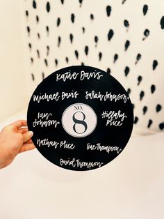 a person holding up a black and white plate with writing on it that says eight days