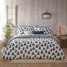 a bed covered in a white and green christmas tree comforter