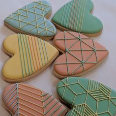 several decorated cookies sitting on top of a white table next to each other with lines