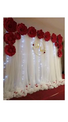 the backdrop is decorated with red roses and white tulle