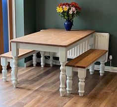 a wooden table with two benches next to it on a hard wood floored room