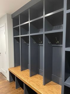 a row of gray lockers sitting on top of a wooden bench in a room