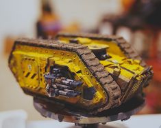 a yellow and black toy tank sitting on top of a table