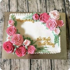 a birthday cake decorated with pink roses and gold lettering