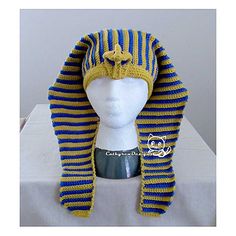 a white mannequin head wearing a blue and yellow striped knitted hat on top of a table