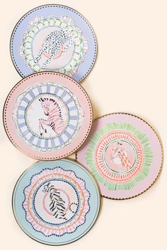 four plates with different designs on them sitting next to each other