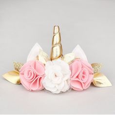 a pink flower crown with gold leaves and a unicorn horn on top is featured in this instagram